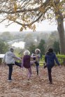 Personas mayores activas estirándose, ejercitándose en el parque de otoño - foto de stock