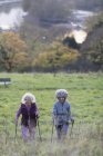Активні літні жінки друзі пішки з полюсами вгору сільський схил пагорба — стокове фото