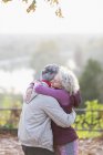 Affectionate active senior couple hugging in park — Stock Photo