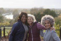 Retrato sonriente, confianza activa de las mujeres mayores amigos en el parque de otoño - foto de stock