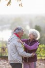 Sorridente, affettuosa coppia anziana attiva che si abbraccia nel parco autunnale — Foto stock