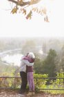 Cariñosa pareja mayor activa abrazándose en el soleado parque de otoño - foto de stock
