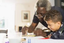 Дедушка помогает внуку с домашним заданием по геометрии — стоковое фото