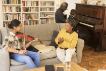 Grandparents and grandchildren playing piano and violin in living room — Stock Photo