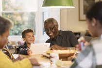 Smiling grandfather and grandson using digital tablet — Stock Photo