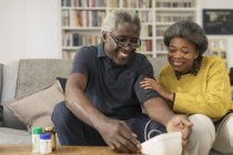 Улыбающаяся пожилая пара проверяет кровяное давление — стоковое фото