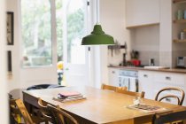 Green pendant light hanging over dining table — Stock Photo
