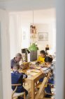 Abuelos en la mesa de comedor con nietos haciendo la tarea - foto de stock