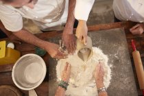 Накладні кухарі роблять тісто для піци борошняне гніздо — стокове фото
