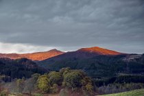 Luce del sole che illumina tranquille cime delle montagne, Scozia — Foto stock