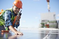 Инженер с рацией, осматривающий солнечную панель на электростанции — стоковое фото