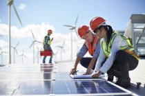 Ingénieurs examinant les plans au panneau solaire de la centrale électrique — Photo de stock