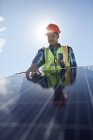Engineer examining solar panel at sunny power plant — Stock Photo