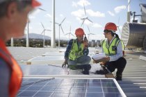 Ingenieros examinan paneles solares en planta de energía alternativa - foto de stock