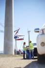 Engineers meeting at truck at sunny wind turbine power plant — Stock Photo