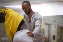 Instrutor de dança ajudando adolescente estudante esticar na aula de dança — Fotografia de Stock