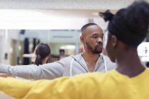 Fokussierter männlicher Instruktor, der Schüler im Tanzkursstudio begleitet — Stockfoto