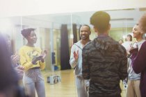 Estudiantes aplaudiendo a instructor masculino en estudio de clase de danza - foto de stock