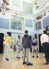 Estudiantes adolescentes escuchando a un instructor masculino en un estudio de danza - foto de stock