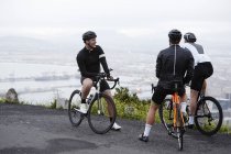 Maschio ciclista amici prendendo una pausa a trascurare — Foto stock
