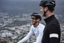 Ciclistas masculinos sonrientes tomando un descanso - foto de stock