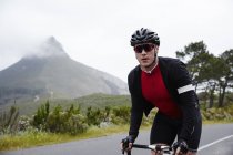Retrato confiante, determinado ciclista masculino ciclismo na estrada — Fotografia de Stock