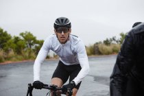Dedicated male cyclist cycling at mountain road — Stock Photo