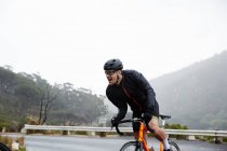 Визначений чоловічий велосипедист, що харчується підйом — стокове фото