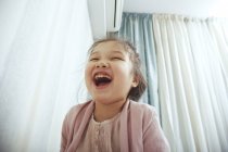 Niedliches, lachendes Mädchen drinnen — Stockfoto