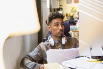 Konzentrierter kreativer Geschäftsmann, der im Büro am Computer arbeitet — Stockfoto