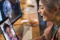 Смеющаяся деловая женщина видео чата с бизнесменом на цифровом планшете — стоковое фото