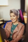 Mujer de negocios creativa sonriente usando tableta digital - foto de stock