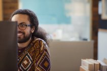 Empresário criativo sorridente trabalhando no computador — Fotografia de Stock