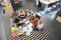 Creative business team meeting, brainstorming in circle on floor in office — Stock Photo