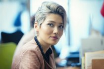 Portrait confident asian businesswoman against blurred background — Stock Photo