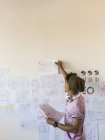 Kreativer Geschäftsmann hängt Papierkram an Bürowand — Stockfoto