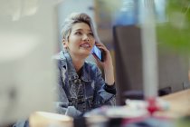 Creative businesswoman talking on smart phone, blurred background — Stock Photo