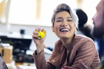 Сміється креативна бізнес-леді стискає стресовий м'яч в офісі — стокове фото