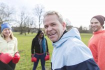 Portrait smiling, confident man boxing with friends in park — Stock Photo