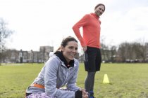 Couple of runners resting in green park — Stock Photo