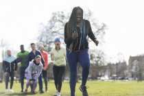 Team cheering woman running in green park — Stock Photo