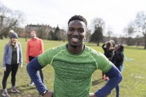 Портрет усміхнений, впевнений чоловік бігун в сонячному парку — стокове фото