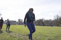 Sorridente, donna fiduciosa che fa trapano scala di velocità nel parco soleggiato — Foto stock