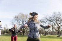Mulher caucasiana feliz exercitando no parque ensolarado — Fotografia de Stock
