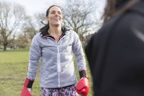 Усміхається жінка боксу в зеленому парку — стокове фото