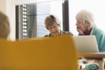 Старші бізнесмени працюють на ноутбуках у конференц-залі зустрічі — стокове фото