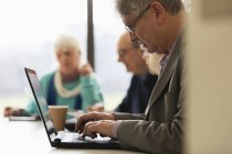 Фокусований старший бізнесмен використовує ноутбук у конференц-залі зустрічі — стокове фото