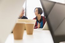 Geschäftsleute sprechen mit Laptops im Konferenzraum — Stockfoto