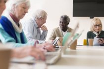 Старші ділові люди розмовляють, використовуючи ноутбуки та цифрові планшети на нараді конференц-залу — стокове фото