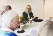 Ritratto donna d'affari anziana fiduciosa con tablet digitale leader riunione sala conferenze — Foto stock
